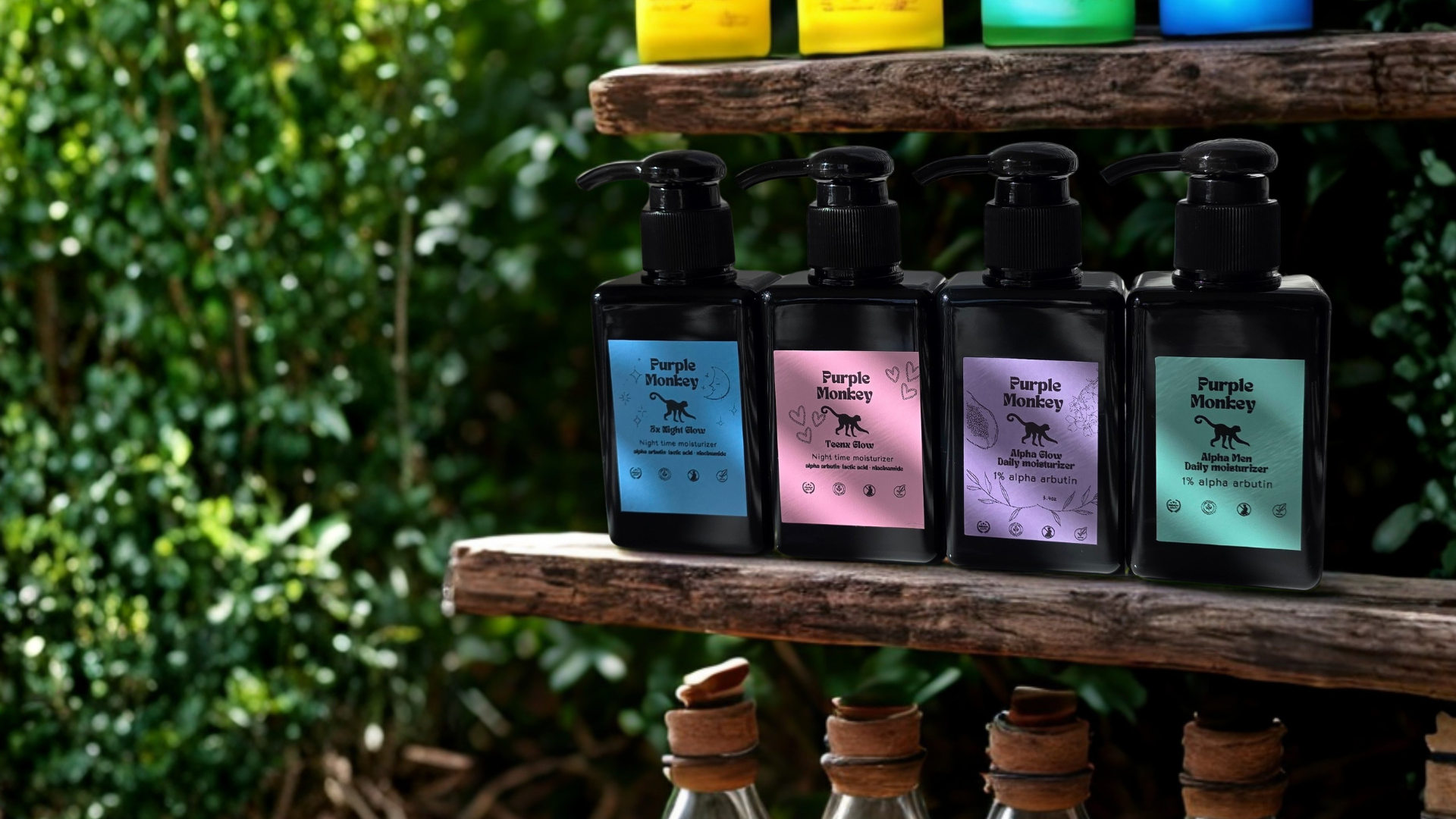 Four black pump bottles of moisturizers, in colors blue, pink, purple and sea green. 